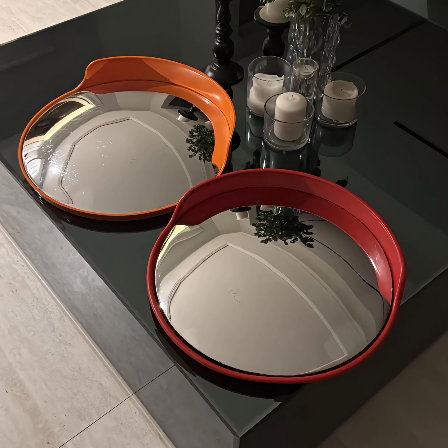 Two round mirrors with orange and red frames on a dark surface.